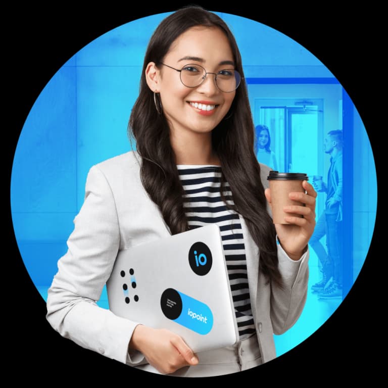 Franqueada da iopoint sorrindo, com um notebook adesivado da marca embaixo do braço